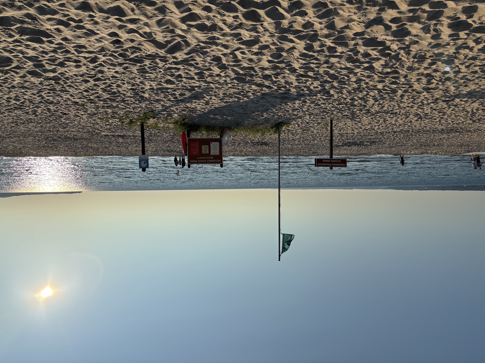 The sun
      is setting over the Swim Flag at the Beach House.